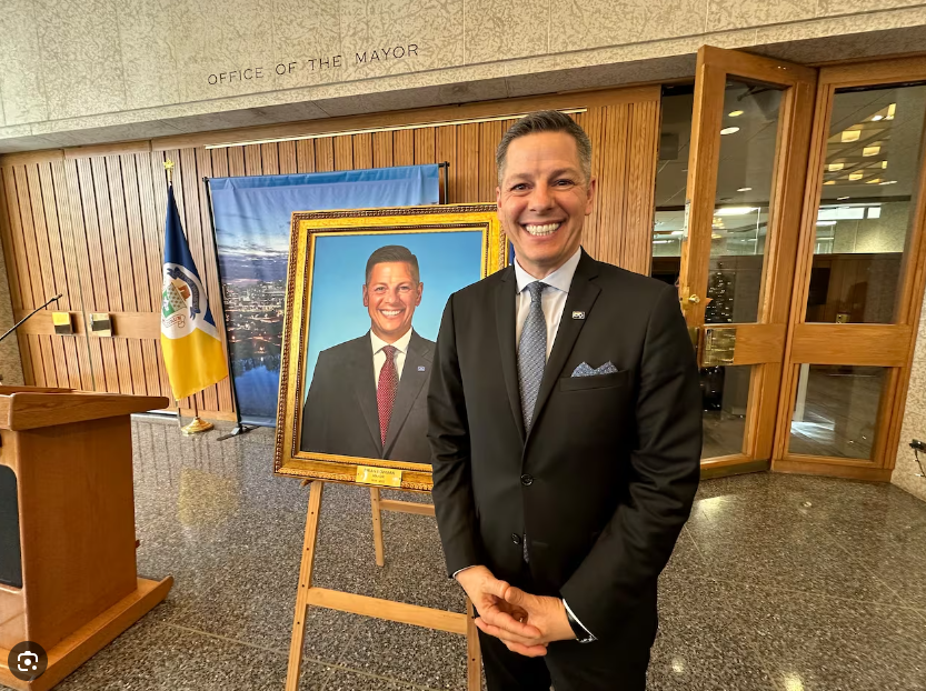 Brian Bowman standing with a portrait of himself.