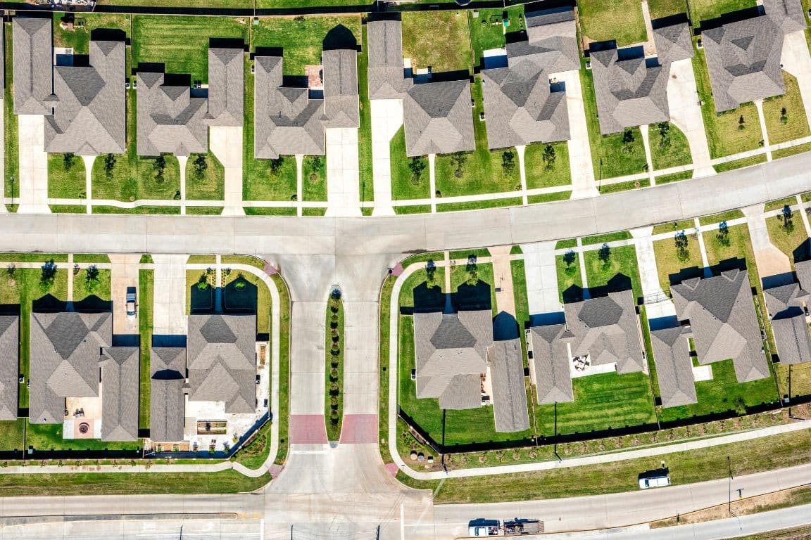 Aerial view of a suburban neighborhood showcasing various houses and green spaces.